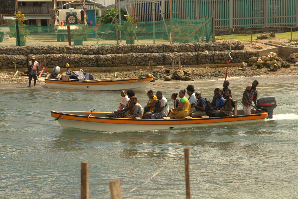 A group of Papua New Guineans sit in a dinghy on the water